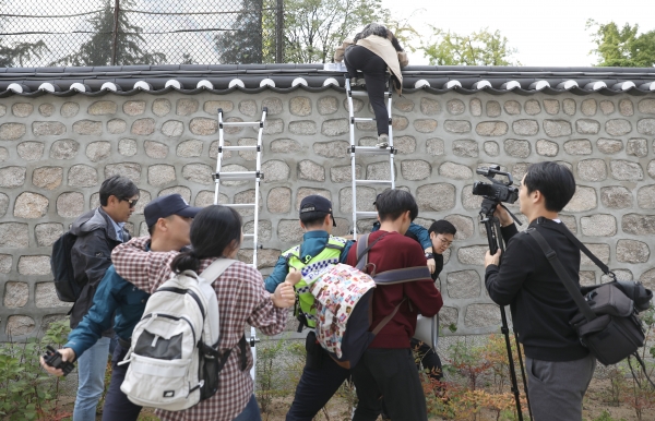 지난 18일 오후 친북 단체인 한국대학생진보연합(대진연) 회원들이 서울 중구 정동 주한 미국대사관저 담장에 사다리를 대고 관저 안으로 넘어들어가고 있다./뉴시스